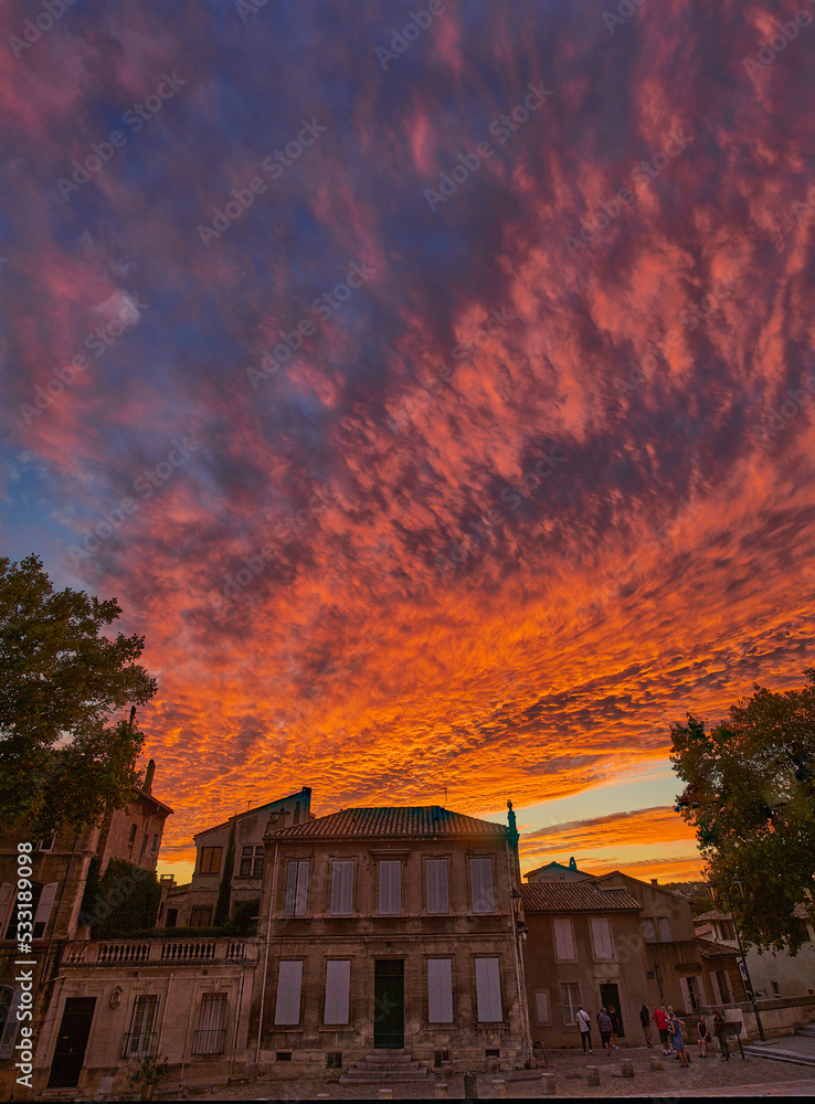 Fototapeta premium Zachód słońca w Avignon, Prowansja, Okcytania, Francja. Płomienie na niebie. Czerwony, purpurowy, karmin, pomarańcz.