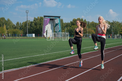 Two athlete young woman runnner are training at the stadium outdoors