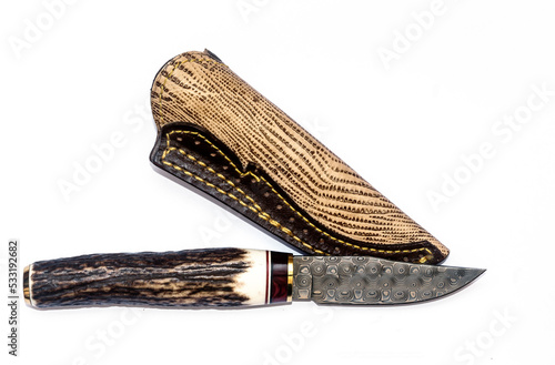 The bowie knighf from Spain. it made from damask steel with the rustic bone handle. The leather scabbard is attached