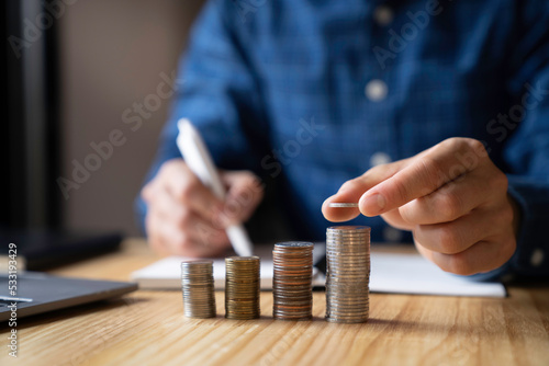 business men holding coins stacked in a row represents financial growth New ideas for saving money, taxes, retirement money