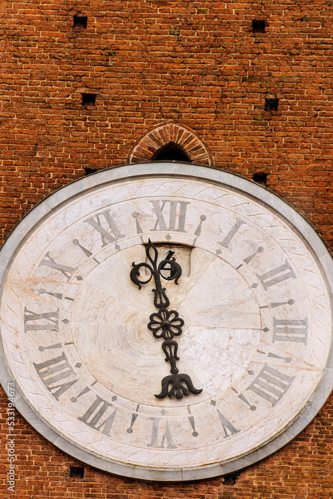 The Tower clock of the Palazzo Pubblico (town hall) was built 1325. The outside of the structure is an example of Gothic Italian medieval architecture. Siena, Italy, 2019