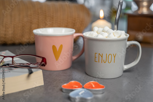 Fotografía tasse enjoy avec chocolat aux guimauves avec décor en fond flou
