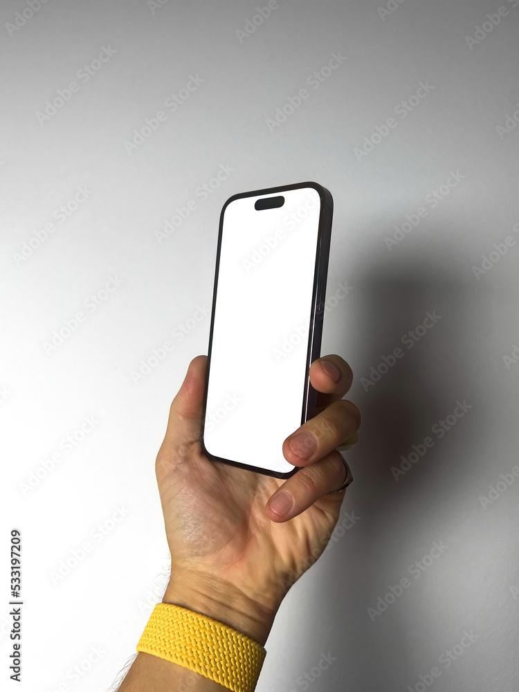 Man hand holding the black smartphone with blank screen and modern frameless design vertical. Isolated on gray background. Mockup and clipping patch Man hand holding the black smartphone with blank screen and modern frameless design vertical. Isolated on gray background. Mockup and clipping patch