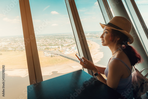 Vászonkép Happy girl looks and admires out of the window on the observation deck of the TV Tower in Dusseldorf