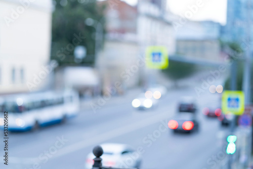 A blurred road, an intersection with cars on a summer day