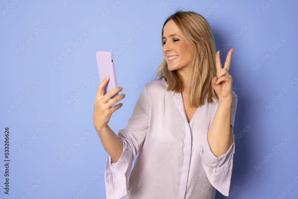 beautiful woman with funny face expression making selfie photo on mobile phone, smiling, happy, isolated, positive mood. beautiful woman with funny face expression making selfie photo on mobile phone, smiling, happy, isolated, positive mood.