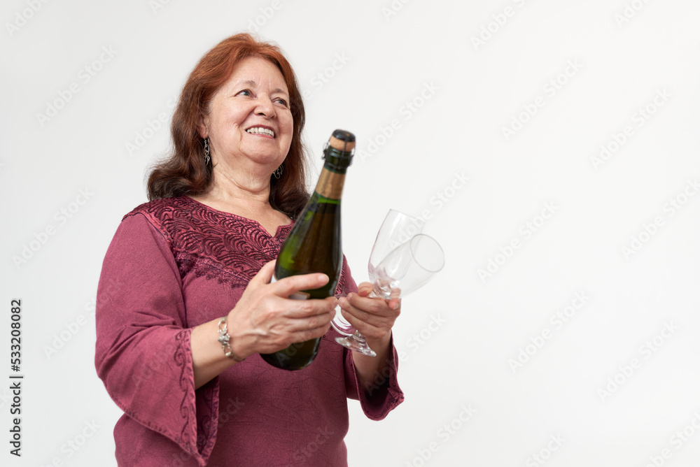 Hispanic mature woman smiling while holding a bottle of champagne or cider and a pair of glasses. Concept of celebratory toast. Composition with copy space. Hispanic mature woman smiling while holding a bottle of champagne or cider and a pair of glasses. Concept of celebratory toast. Composition with copy space.