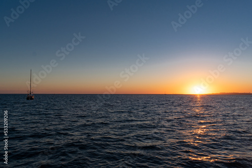 sunset over the sea with sailboat © AGORA Images