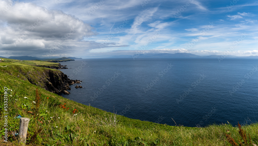 coastal landscape with green meadows and rugged cliffs on a beautiful summer day on the Dingle Peninsula of County Kerry in western Ireland