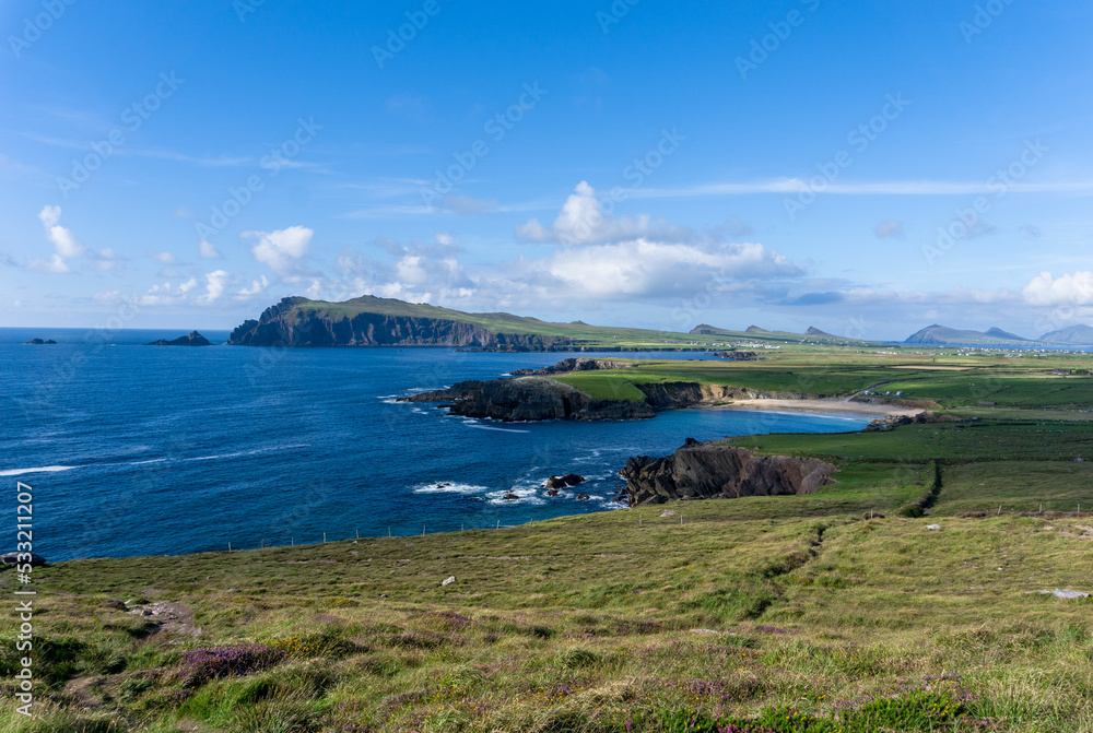 coastal landscape with green meadows and rugged cliffs on a beautiful summer day on the Dingle Peninsula of County Kerry in western Ireland