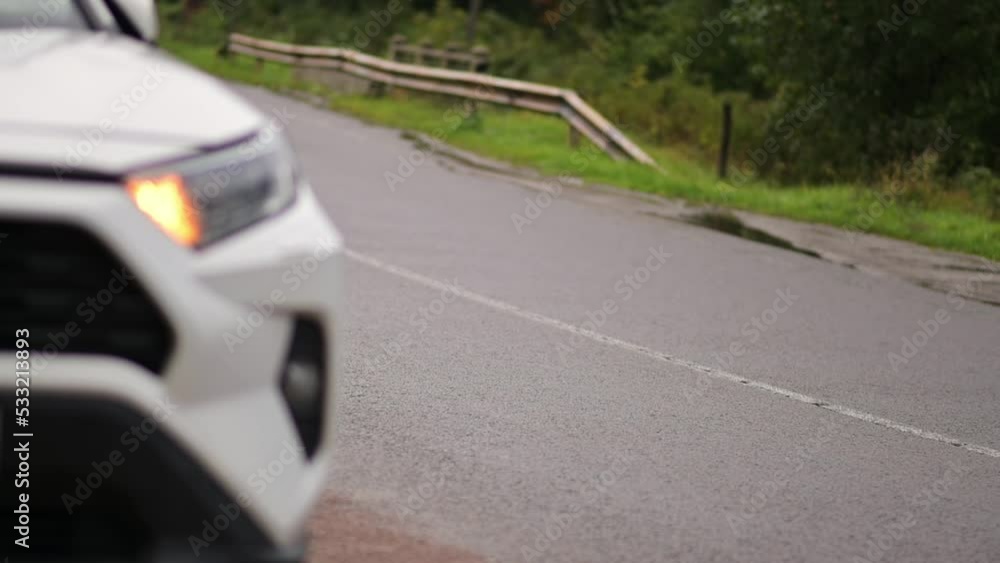 A car with an activated emergency signal is standing on the side of the highway. Emergency situation. Wet road. Emergency gang. A car with an activated emergency signal is standing on the side of the highway. Emergency situation. Wet road. Emergency gang.