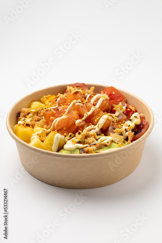 Poke with salmon, pineapple and avocado with spicy sauce on a white background