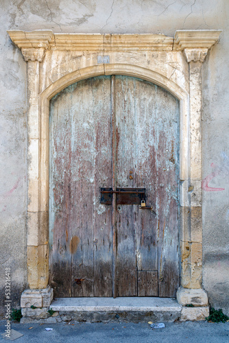 Obsolete old wooden front door in stone doorway 