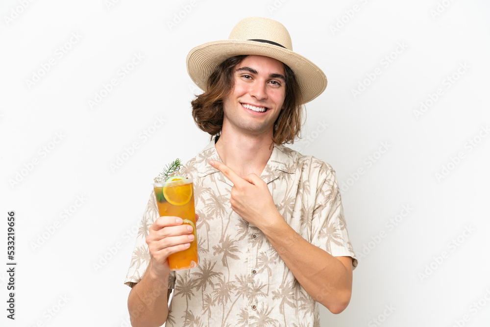 Young handsome man holding a cocktail isolated on white background pointing to the side to present a product