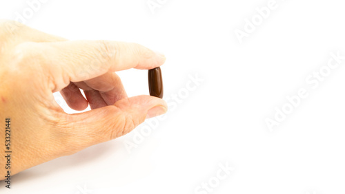 Woman hand taking a pill on white background. Health care concept idea. Selective focus