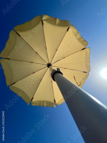 Low angle photograph of umbrella and blue sky