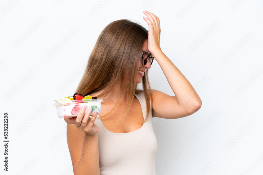 Young pretty woman holding a bowl of fruit isolated on white background has realized something and intending the solution Young pretty woman holding a bowl of fruit isolated on white background has realized something and intending the solution