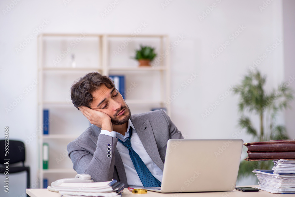 Young male employee in oversleeping concept Young male employee in oversleeping concept