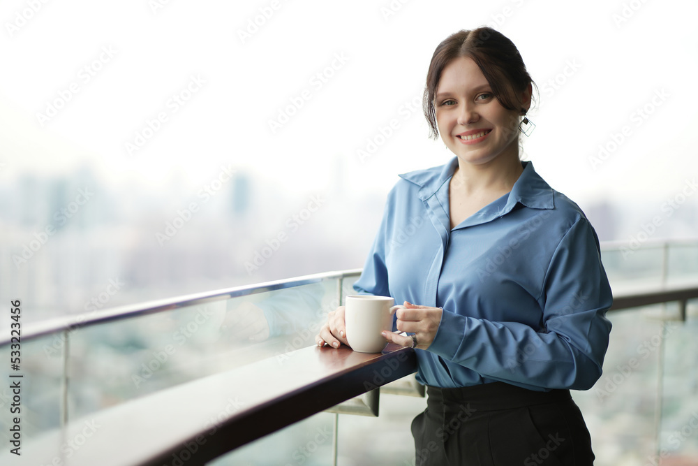 Young businesswoman drinking coffee in her office. Woman enjoy in coffee break.