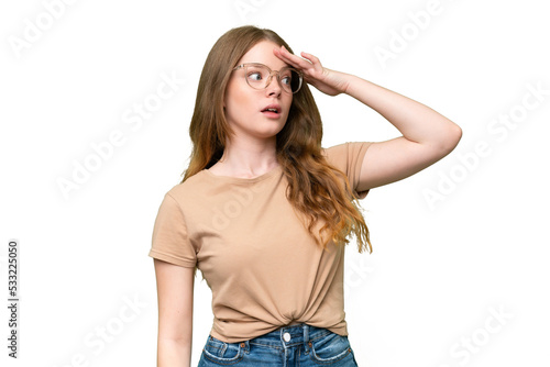 Young pretty woman over isolated background doing surprise gesture while looking to the side