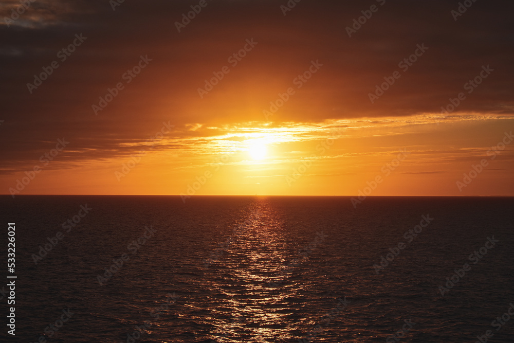 orange yellow blue sunrise sunset reflection over ocean sea 