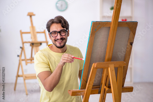 Young man enjoying painting at home