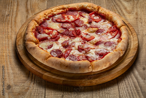 Delicious pizza served on wooden plate