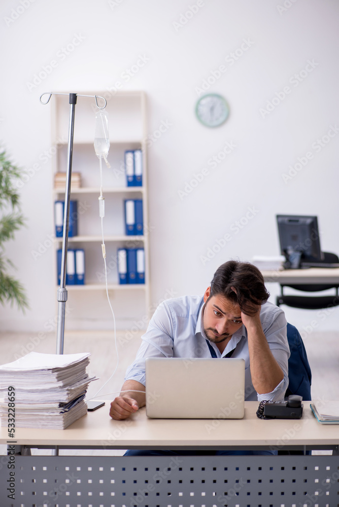 Young male employee suffering at workplace Young male employee suffering at workplace