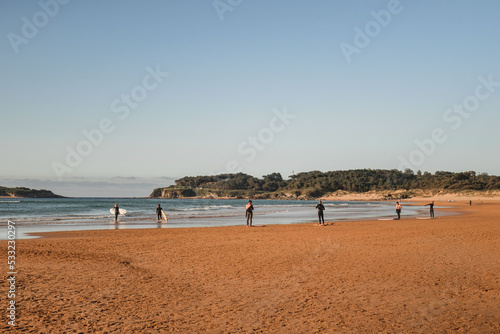 group of surfers on the beach as they prepare to enter the water for surfing during a surf and travel week experience in Somo, Cantabria (Spain) © Raffaele Conti RC88
