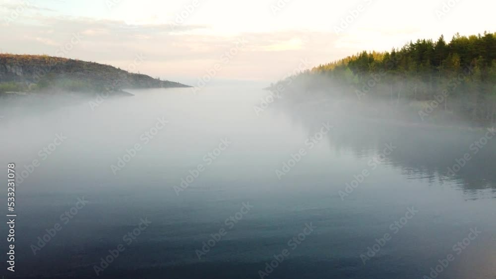 Flying a drone over the water surface through a picturesque fog Flying a drone over the water surface through a picturesque fog