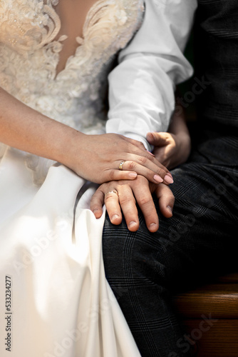 hugging hands of newlyweds with rings close-up