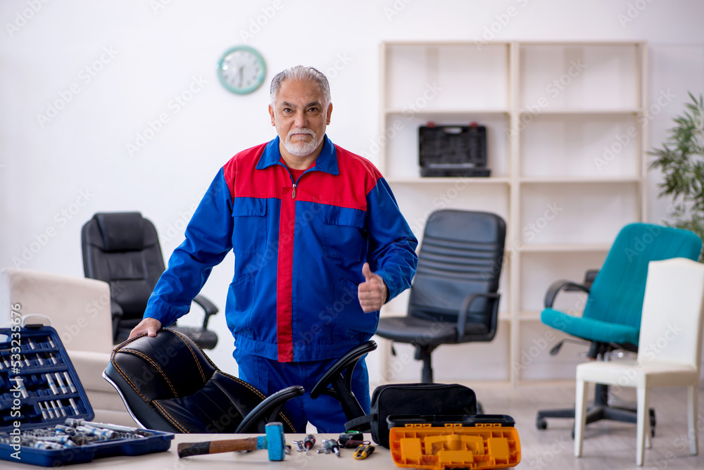 Old male repairman repairing office chair Old male repairman repairing office chair