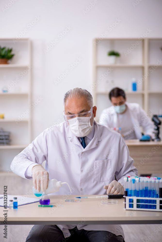 Two male chemist working at the lab Two male chemist working at the lab