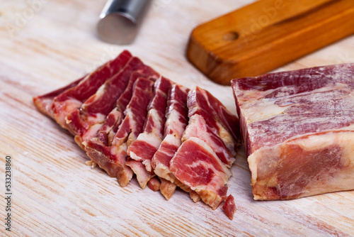 Appetizing sliced jerky boneless pork tenderloin on wooden background. Meat snack
