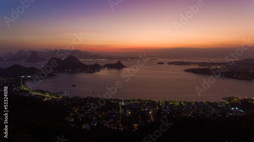 Aerial view of the sunset over Guanabara Bay from the City Park of Niterói. In the background, the mountains Pão-de-Açucar, Corcovado, and Pedra da Gávea, postcards of the city of Rio de Janeiro.