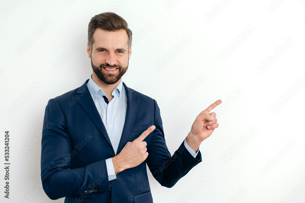 Positive confident caucasian man, in elegant suit, pointing aside with fingers hands gesture at empty space for presentation or advertising, stand on isolated white background, looks at camera, smiles Positive confident caucasian man, in elegant suit, pointing aside with fingers hands gesture at empty space for presentation or advertising, stand on isolated white background, looks at camera, smiles