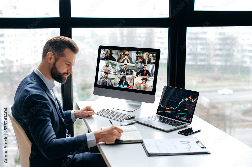 Positive smart successful caucasian male trader, stock investor, talking with multiracial colleagues on video conference, discussing risks and growth prospects of cryptocurrency, taking notes Positive smart successful caucasian male trader, stock investor, talking with multiracial colleagues on video conference, discussing risks and growth prospects of cryptocurrency, taking notes