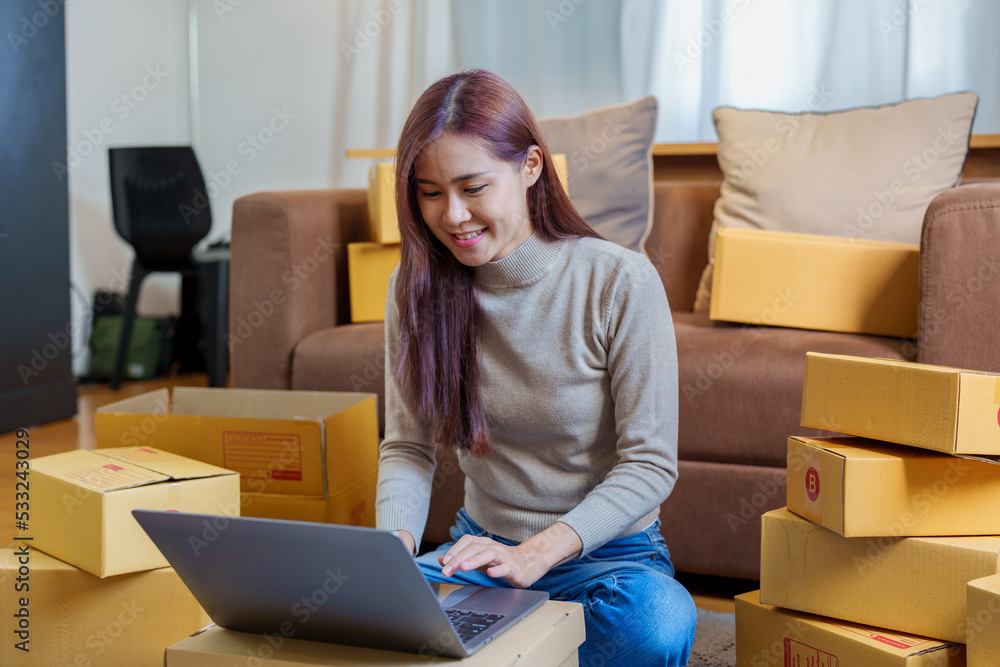 A portrait of a small startup, an SME owner, an Asian female entrepreneur checking orders to arrange the produce before packing the products in the inner boxes with the customers. Freelance concepts A portrait of a small startup, an SME owner, an Asian female entrepreneur checking orders to arrange the produce before packing the products in the inner boxes with the customers. Freelance concepts