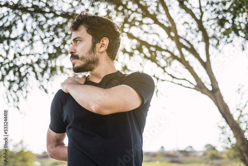Fototapeta Naklejka Na Ścianę i Meble -  Getting ready to do his best. Portrait of a sporty young man stretching his back while exercising outdoors.