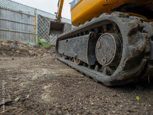 close up of mini digger tracks on soil in a garden