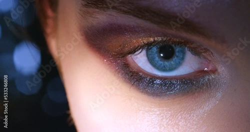 Blue eye, eyeshadow makeup and woman with dilating pupils reaction after drug. Face closeup and zoom into human iris. Eyeball, retina and looking at camera with compelling vision or mydriasis photo