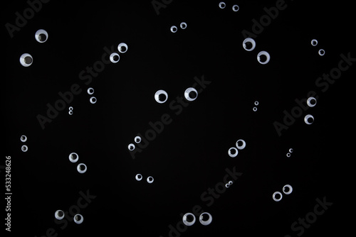 Funny face made from jiggly eyes on black background