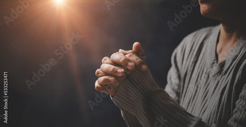 Christ religion and christianity worship or pray concept. Christian catholic woman are praying to god in dark at church. Prayer person hand in black background. Girl believe and faith in jesus christ.