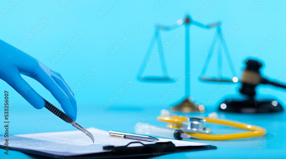 Operation being performed by a doctor while a Patient relative signs a document agreement with consent. scalpel blade used as a pen for lawyer legal documents insurance and protection, copy space Operation being performed by a doctor while a Patient relative signs a document agreement with consent. scalpel blade used as a pen for lawyer legal documents insurance and protection, copy space