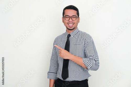 Asian businessman smiling confident at camera while pointing to the right side photo