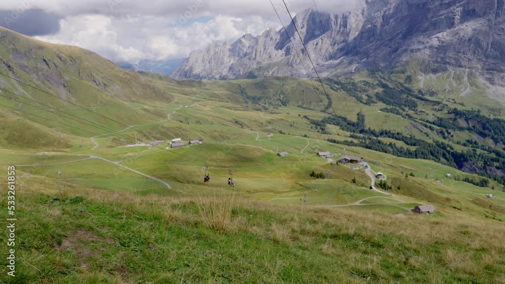 Two people zip lining down a hill at Grindelwald first in Switzerland. Slowed to half speed Two people zip lining down a hill at Grindelwald first in Switzerland. Slowed to half speed