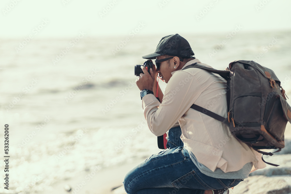 Tourists use camera to shoot sunset on the beach. backpacker and travel concept.