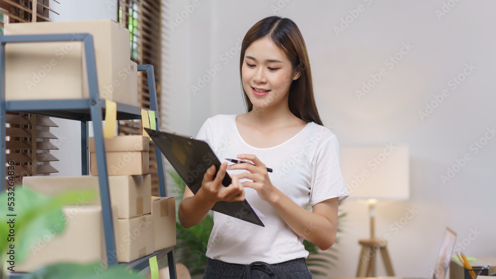 Online selling concept, Asian business women holding clipboard to checking products in store
