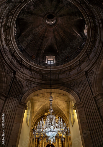 Hanging glass lamp of the Pilgrim in the church of Pontevedra with the beautifully lit altar in the background and a view of the dome