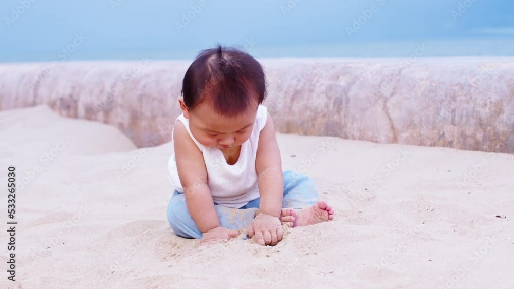 Adorable asian baby sit on sand spend time to learn all around beach and sea. Adorable asian baby sit on sand spend time to learn all around beach and sea.